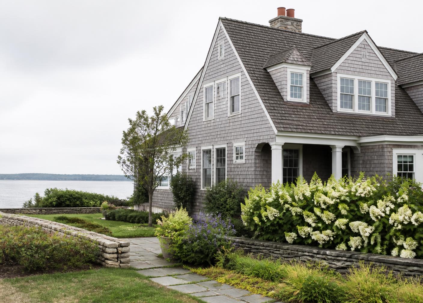 A shingled New England coastal home on a quiet Maine morning